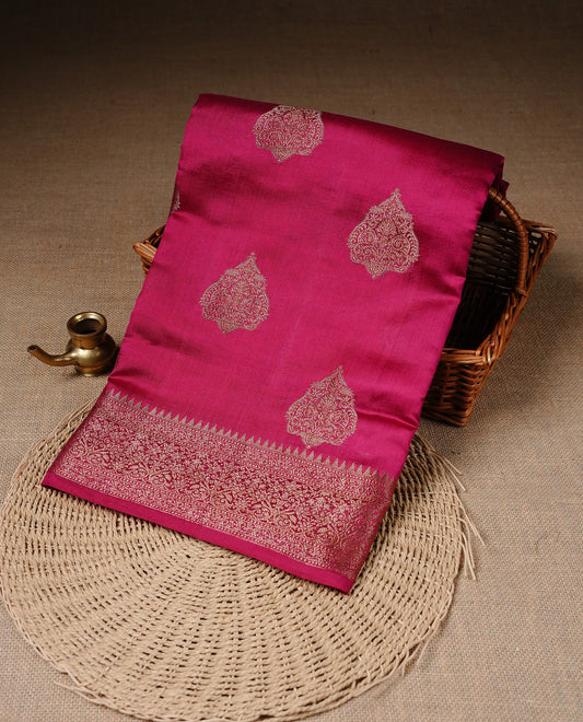 Magenta Colour Pure Banaras Soft Silk saree featuring Antique Zari buttas in body, complemented by zari work on self colour border, paired with matching Blouse Piece.