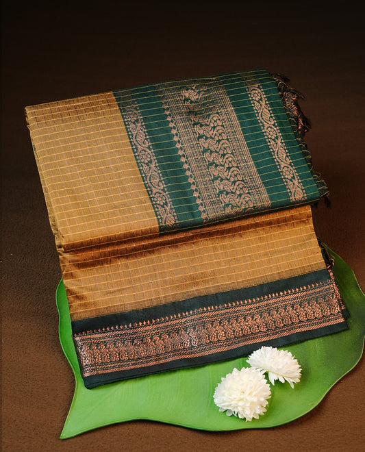 Mustard colour kalyani cotton saree featuring gold zari check pattern on body, complemented by green colour with Antique zari border, paired with matching blouse piece.