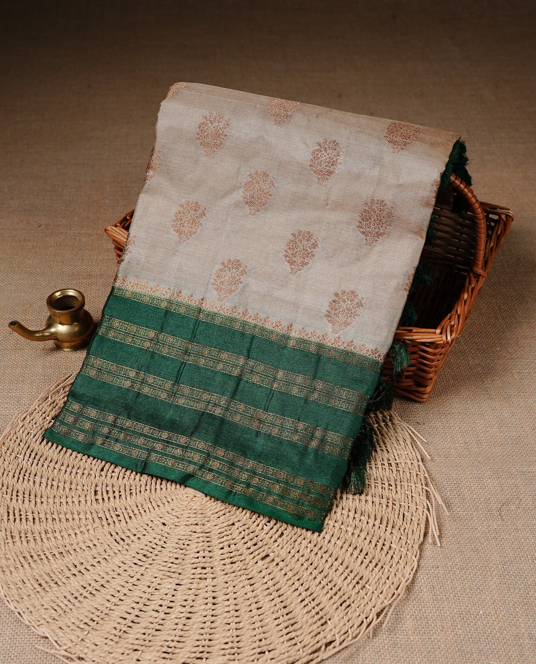 Golden Cream Colour Banaras tussar silk saree featuring Antique zari Motifs on body, Complemented by green colour variant with zari border, paired with matching blouse Piece.