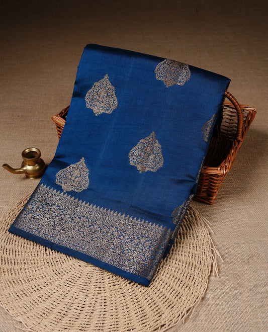 Teal Colour Pure Banaras Soft Silk saree featuring Antique Zari buttas in body, complemented by zari work on self colour border, paired with matching Blouse Piece.