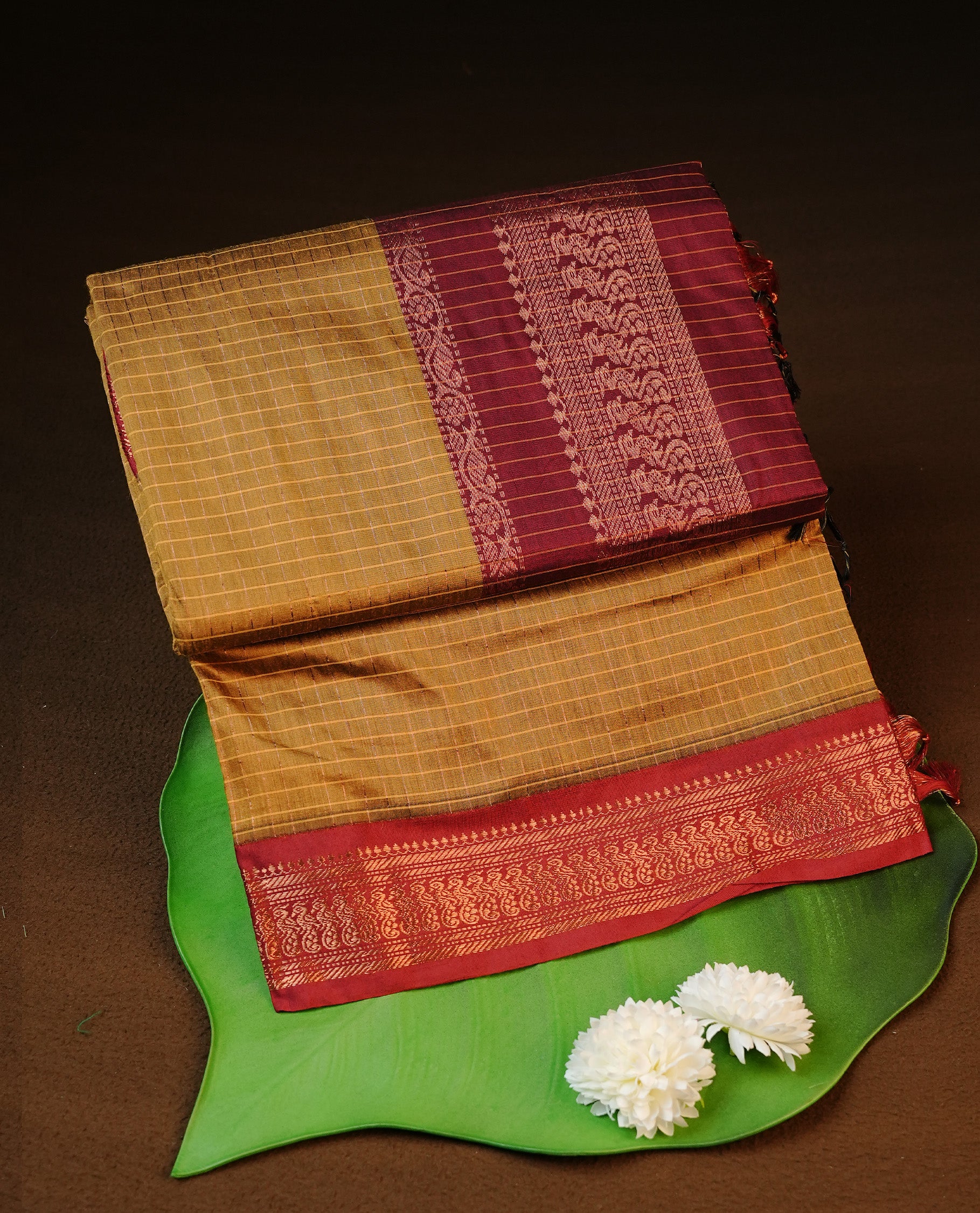 Mustard colour kalyani cotton saree featuring antique zari check pattern on body, complemented by Maroon colour with Antique zari border, paired with matching blouse piece.