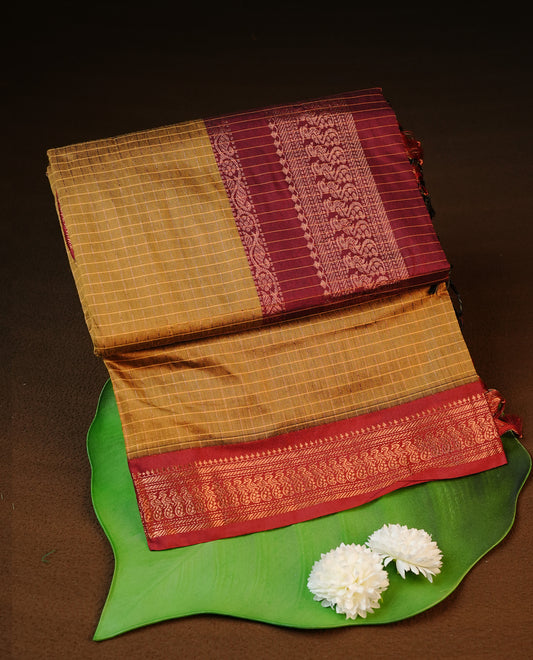 Mustard colour kalyani cotton saree featuring antique zari check pattern on body, complemented by Maroon colour with Antique zari border, paired with matching blouse piece.