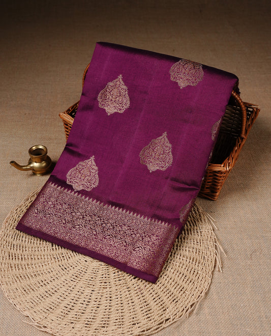 Burgundy Colour Pure Banaras Soft Silk saree featuring Antique Zari buttas in body, complemented by zari work on self colour border, paired with matching Blouse Piece.