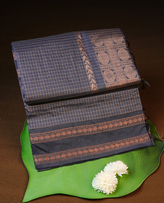 Grey colour kalyani cotton saree featuring gold zari check pattern on body, complemented by self colour with Antique zari border, paired with matching blouse piece.