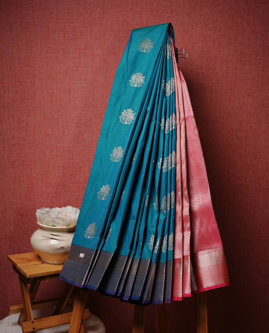 Green colour Semi silk saree Featuring gold zari motifs on body, complemented by contrast Peacock colour with gold zari border, paired with matching blouse piece.