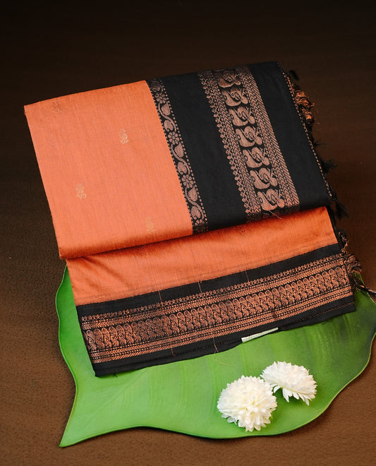 Orange colour kalyani cotton saree featuring antique zari motifs on body, complemented by Black colour with Antique zari border, paired with matching blouse piece.