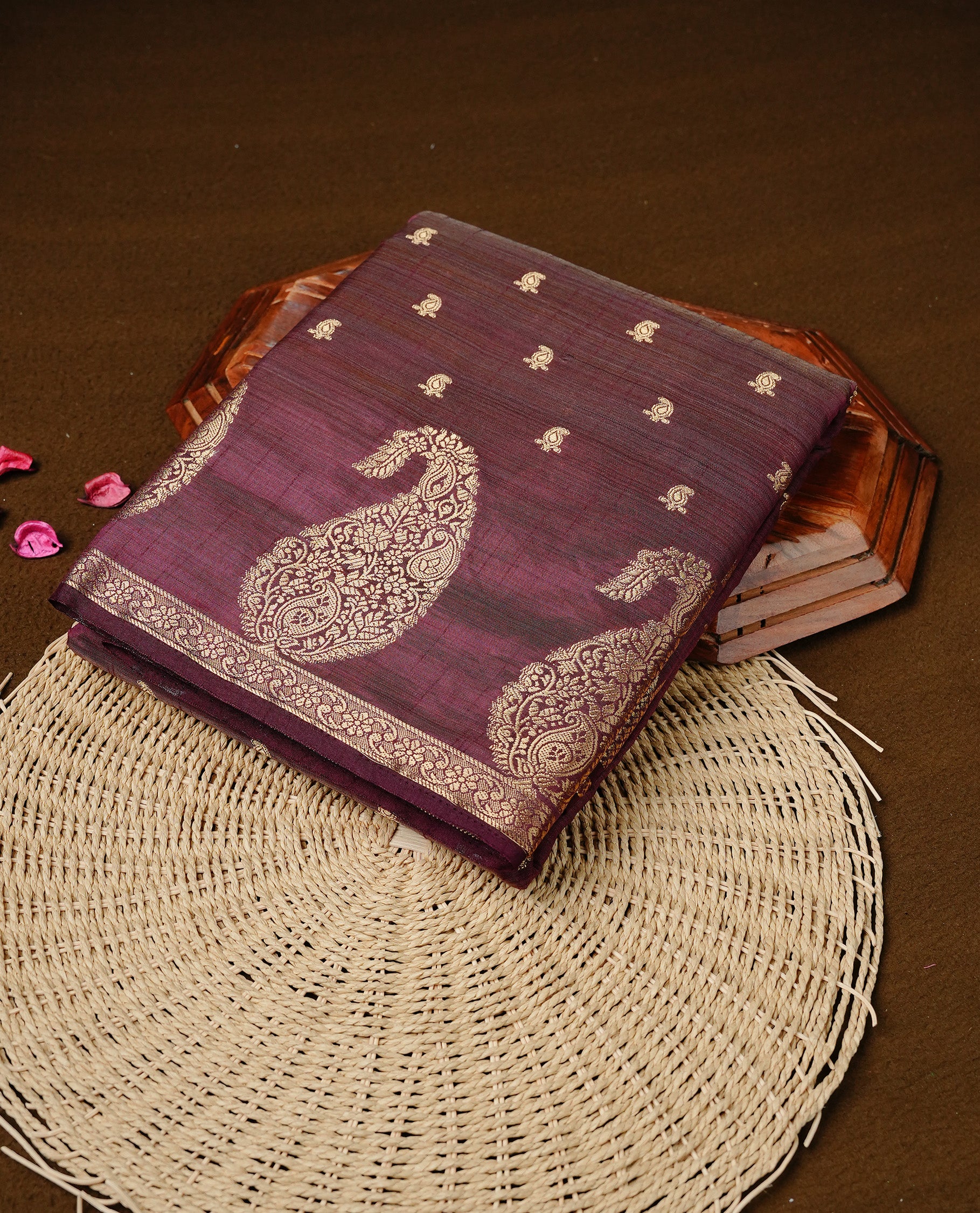 Chocolate brown colour semi tussar silk saree featuring small gold zari mango motifs across the body, enhanced with a self colour border showcasing elegant gold zari mango patterns. Paired with a matching blouse piece.