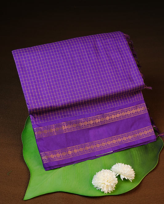 Indigo colour kalyani cotton saree featuring gold zari check pattern on body, complemented by Self colour with Antique zari border, paired with matching blouse piece.