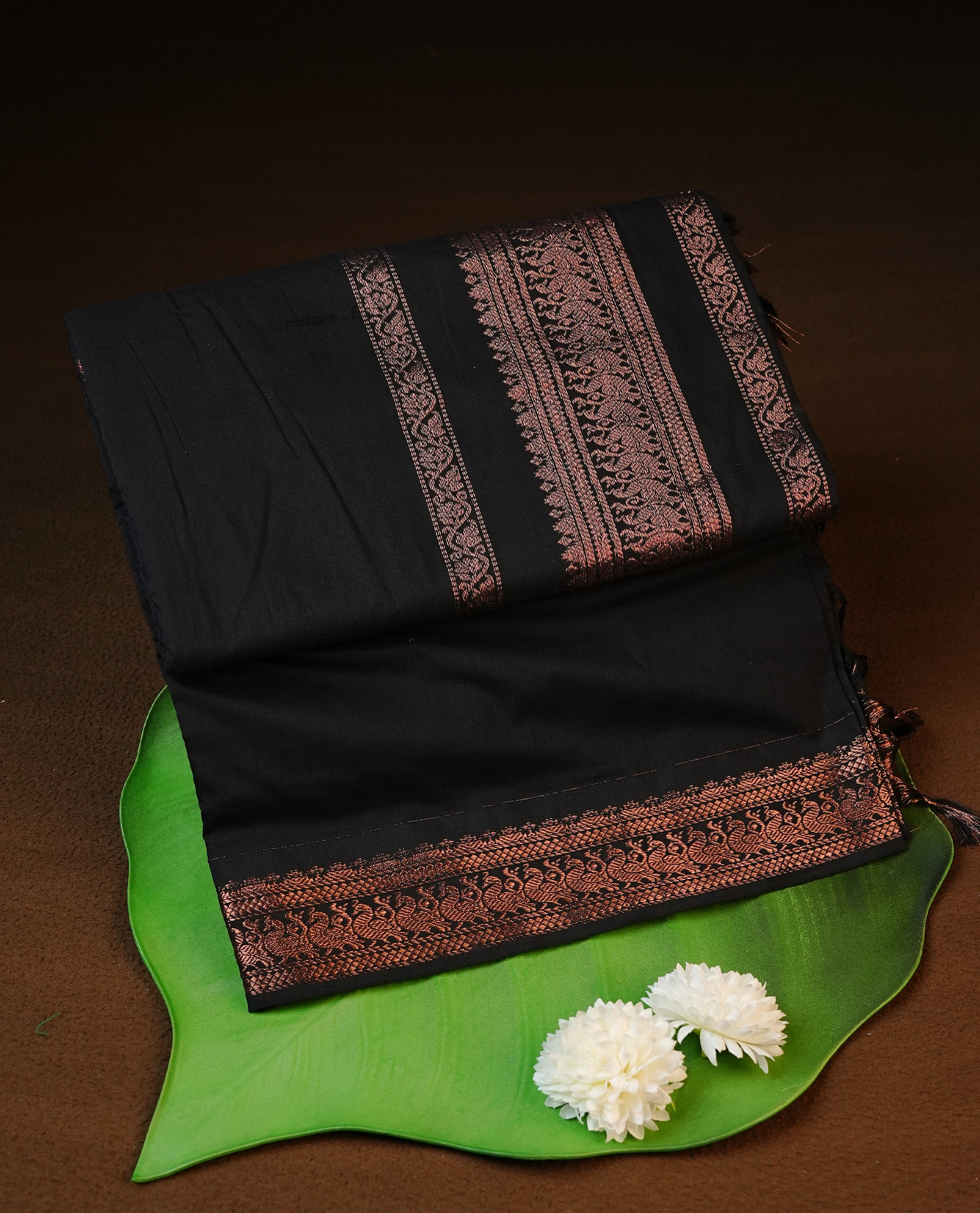 Black colour kalyani cotton saree featuring elegant plain body, complemented by self colour with Antique zari border, paired with matching blouse piece.
