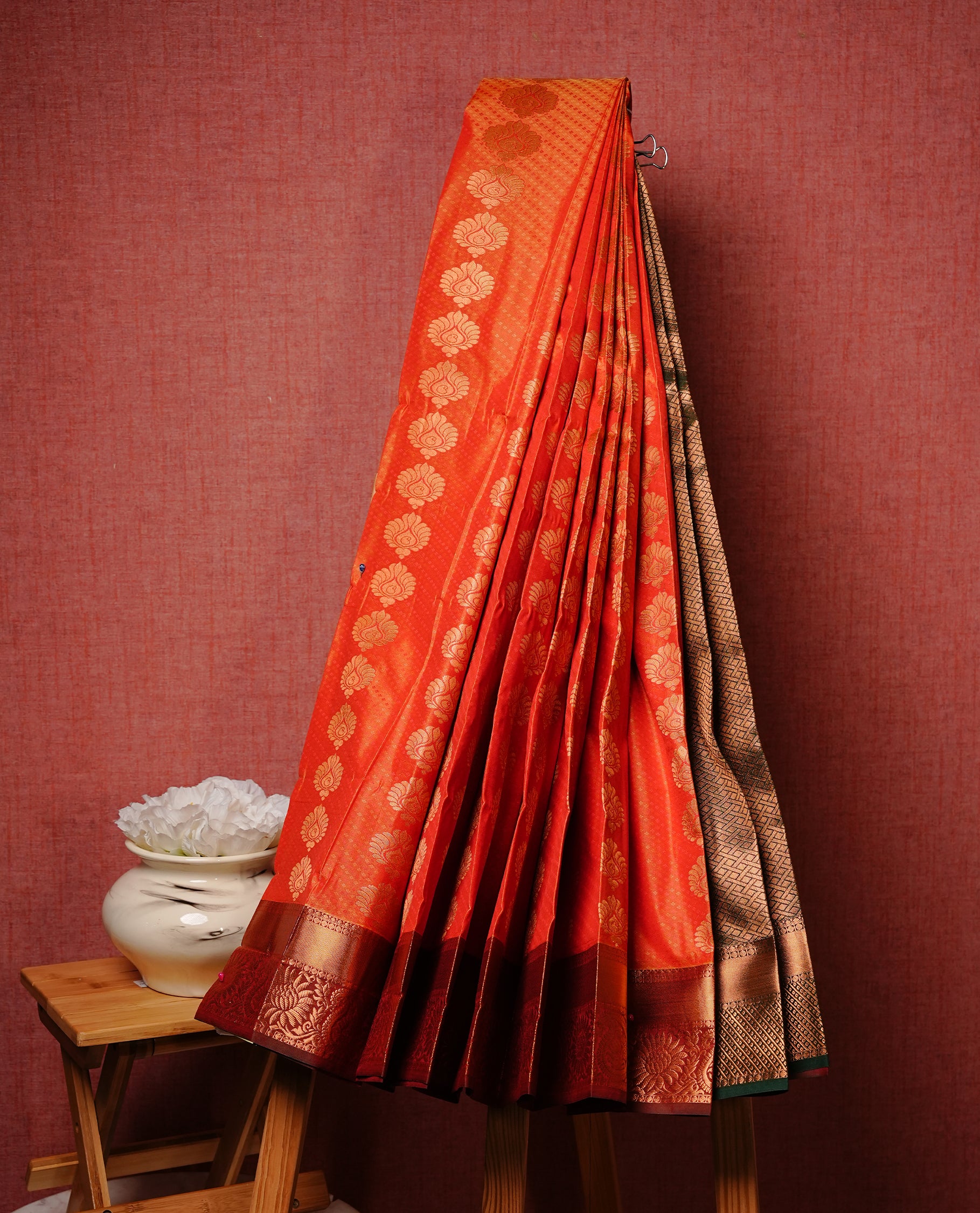 Rust Orange colour Semi silk saree Featuring gold zari motifs on body, complemented by contrast Maroon colour with gold zari border, paired with matching blouse piece.