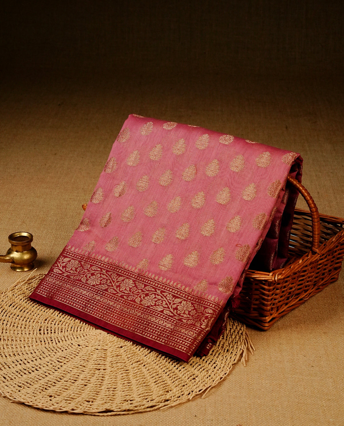 Pink colour banaras silk saree featuring gold zari buttas on body, complemented by contrast Red with gold zari border, comes with matching blouse piece.