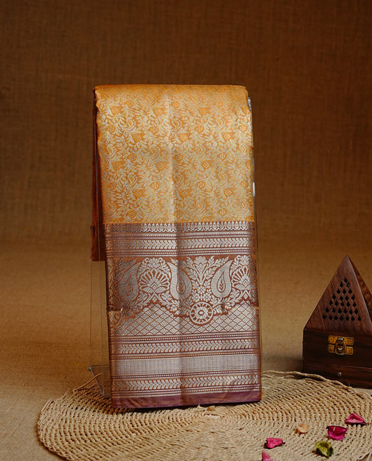 Yellow colour Semi tissue silk saree featuring Light gold zari kodi floral motifs on body, Contrast Brown colour with traditional border, paired with matching blouse piece.