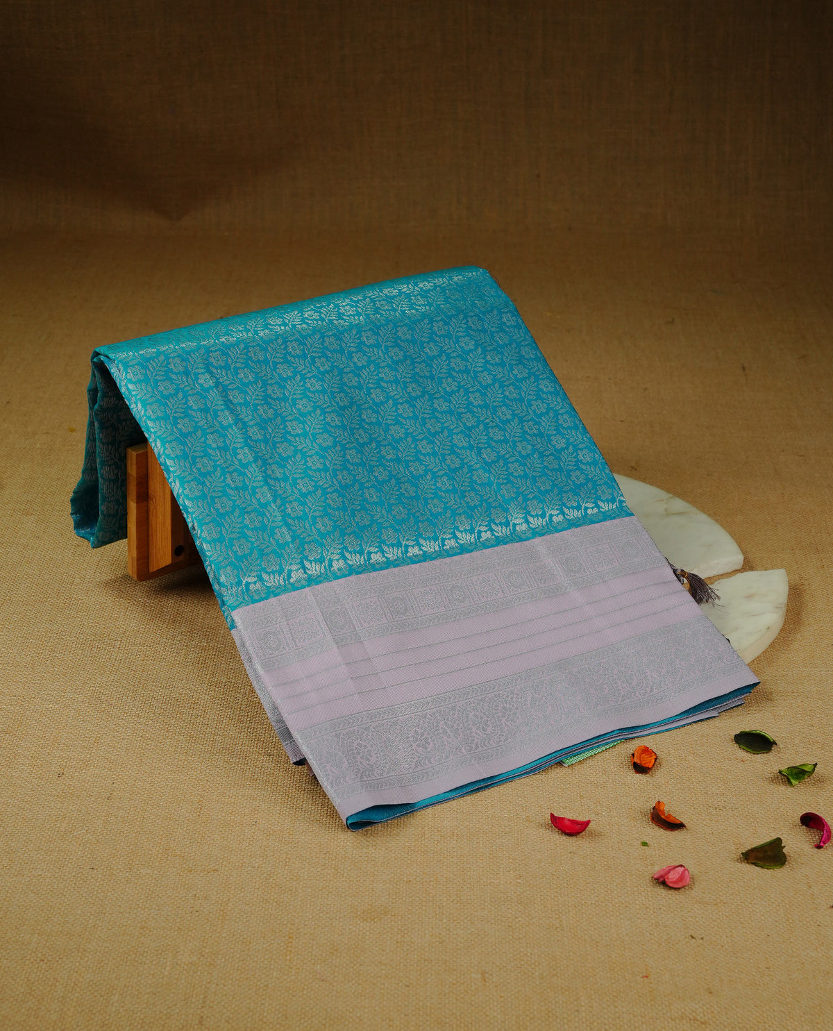 Aqua blue colour semi silk saree featuring Silver zari Floral pattern on body, complemented by contrast Grey colour with silver zari border, comes with matching blouse piece.