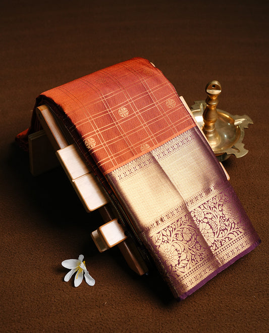 Brown colour semi wedding saree featuring gold zari motif on check pattern on body, complemented by contrast burgundy with traditional border, paired with matching blouse piece.
