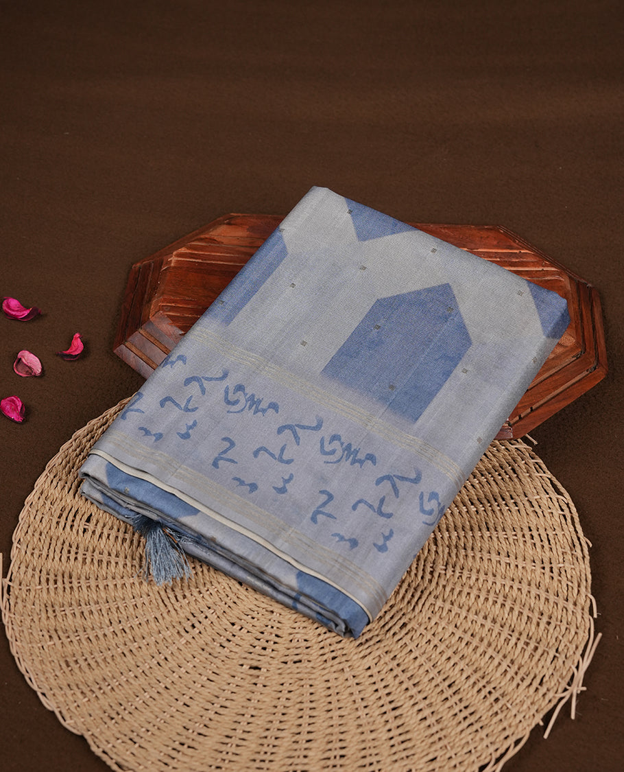 Steel blue colour semi tusser silk saree featuring geometric print pattern across body, gold zari border with style motifs and paired with matching blouse.