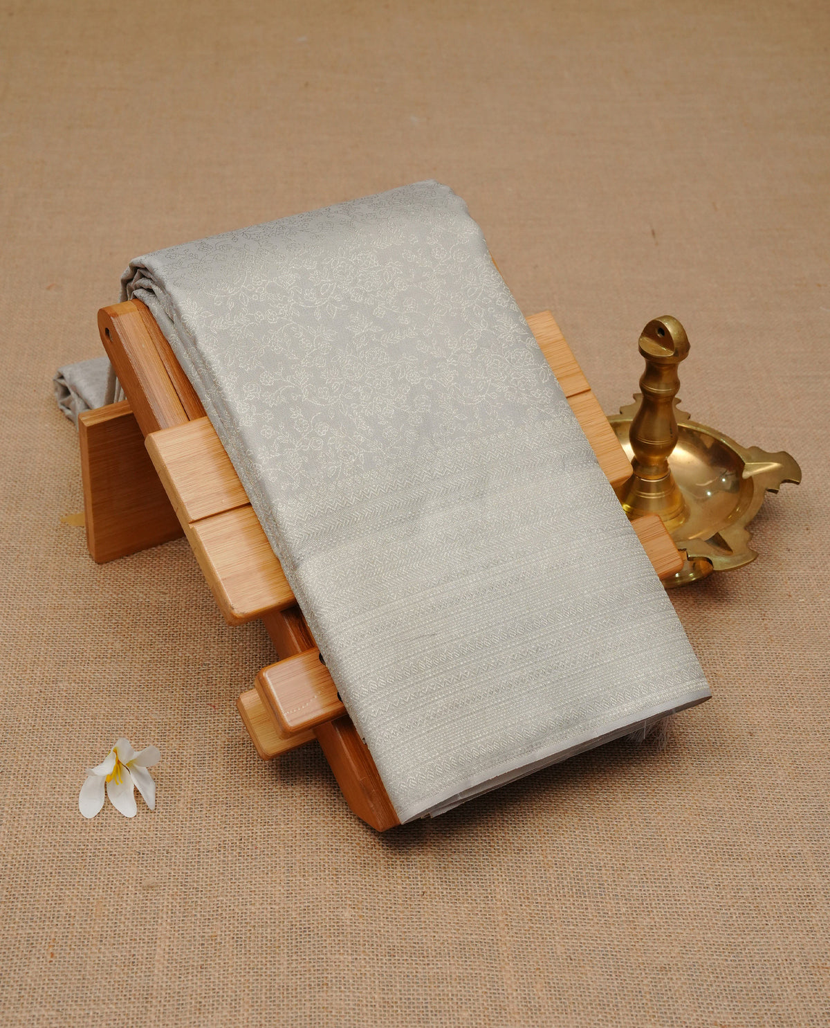 Grey colour pure wedding silk saree featuring Silver zari Floral kodi pattern on body, complemented by self colour with traditional border, comes with matching blouse piece.