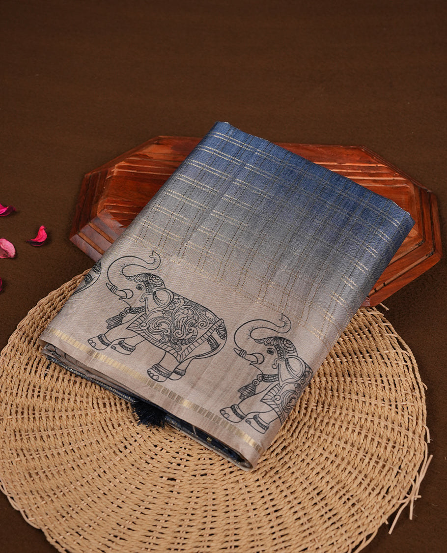 Ash blue colour semi tusser silk saree featuring Gold zari check pattern across body, faded contrast cream colour border with elephant print and paired with matching blouse.