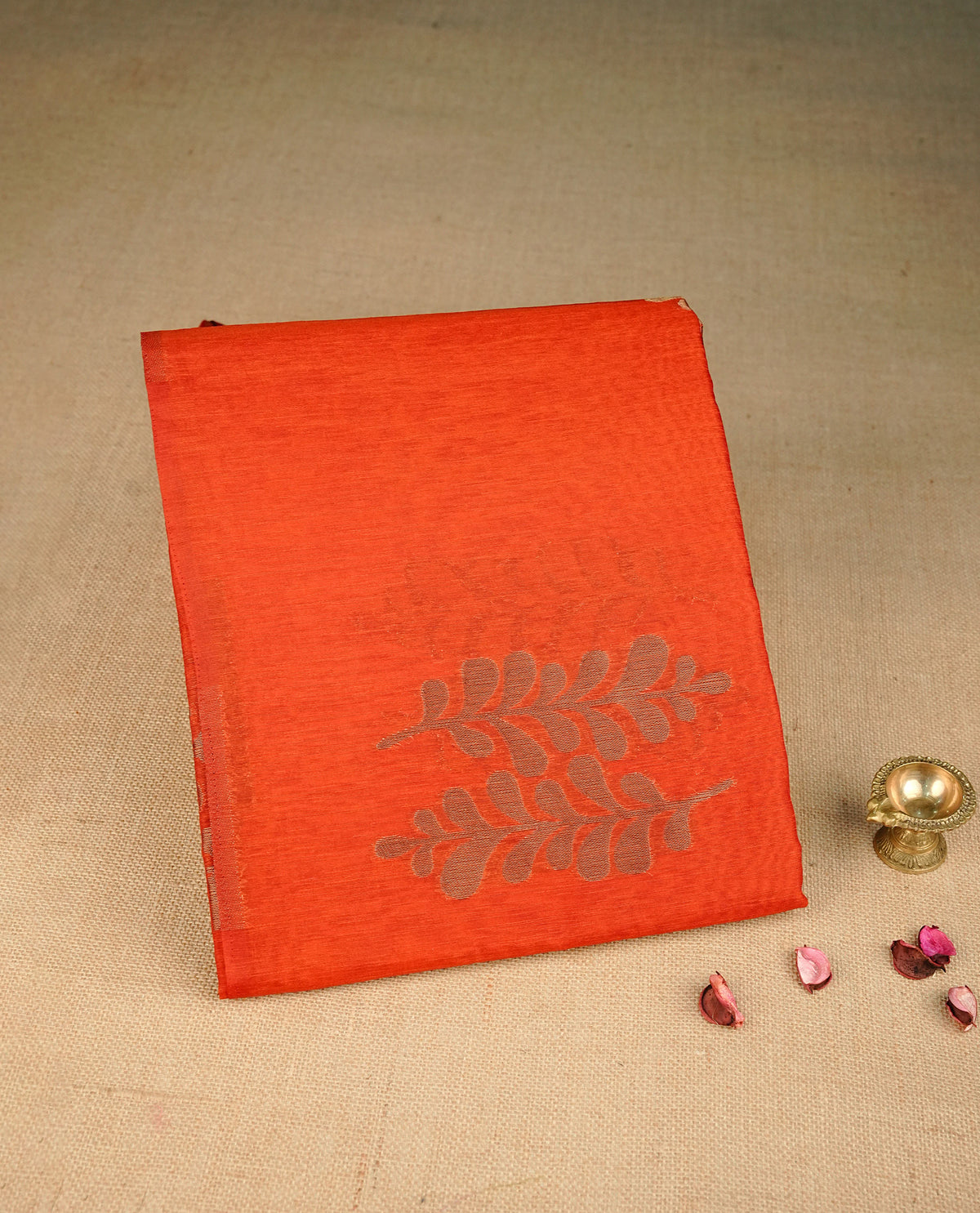 Brick red colour semi silk saree featuring Gold zari Leaf pattern on body, complemented by contrast  colour with Gold zari border, comes with matching blouse piece.