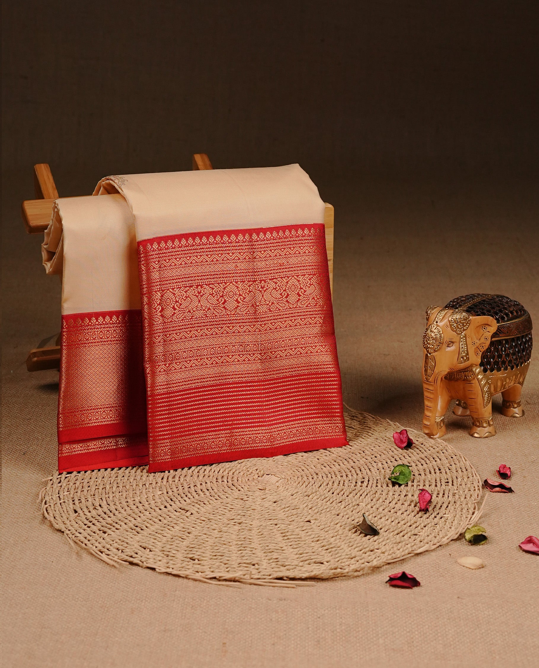 Cream colour Traditional Kancheepuram silk saree featuring gold zari motifs on body, enhanced with contrast Red with traditional border, paired with matching blouse piece.