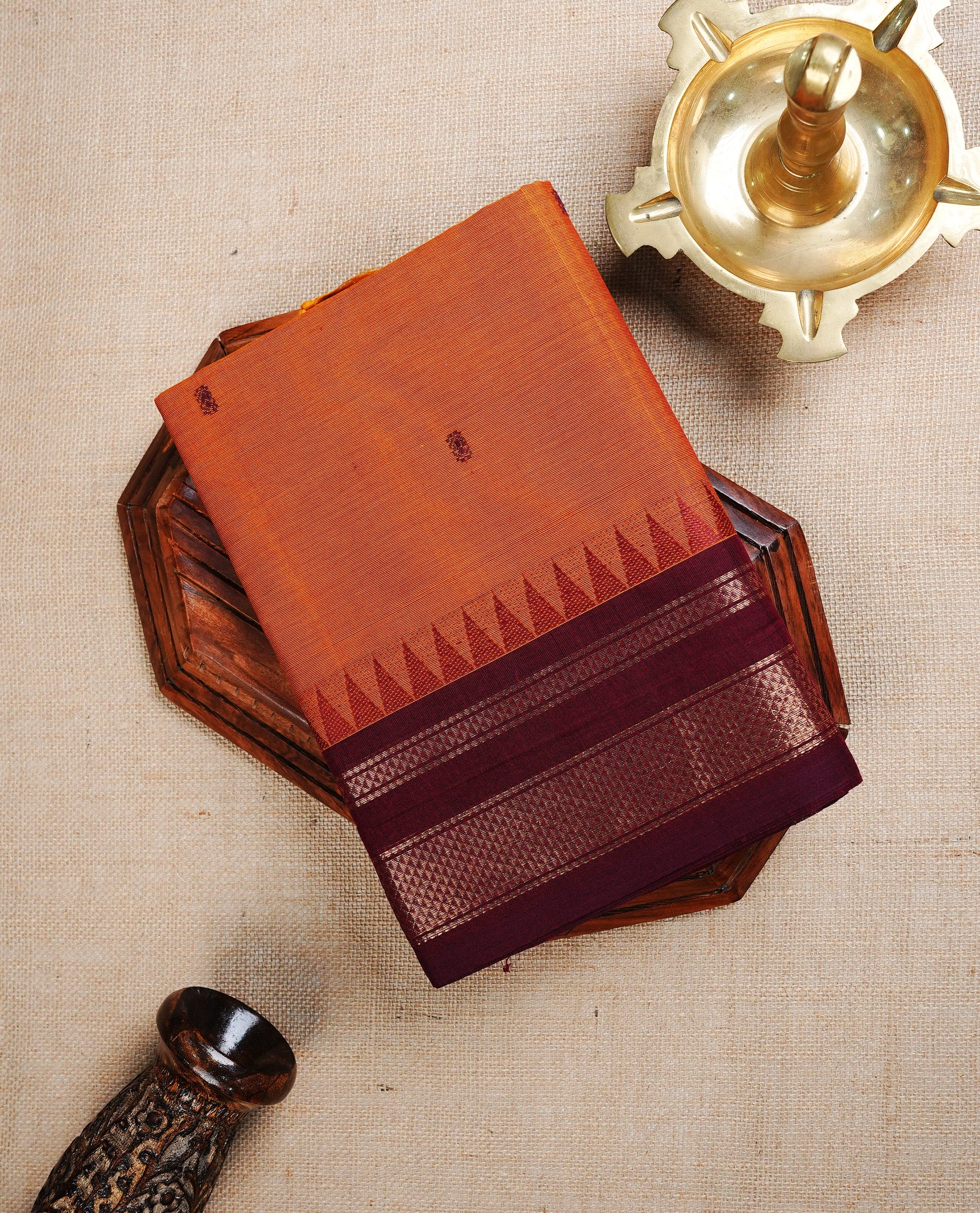 Rust Orange colour chettinad cotton saree featuring  Maroon Motifs  on body, complemented by Contrast Maroon Colour With Gold Zari border, paired with matching blouse piece.
