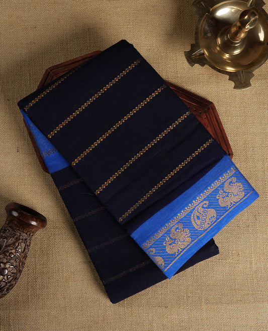 Navy blue colour Chettinad cotton saree featuring golden stripes on the body, The saree is enhanced with a contrasting blue border adorned with intricate golden paisley motifs & Comes with a matching blouse piece.