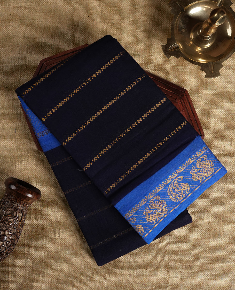 Navy blue colour Chettinad cotton saree featuring golden stripes on the body, The saree is enhanced with a contrasting blue border adorned with intricate golden paisley motifs & Comes with a matching blouse piece.