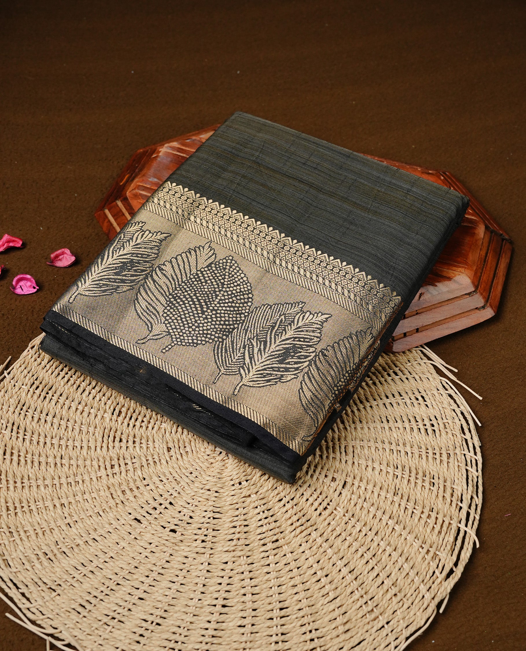 Blackish Grey colour semi tussar silk saree featuring an elegant plain body with traditional gold zari detailed border for a refined look. Comes paired with a matching blouse piece.
