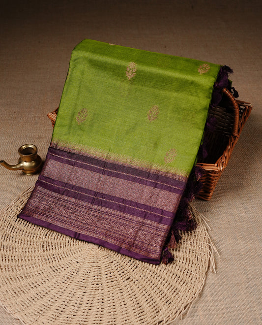 Olive Green colour Pure Banaras Tussar silk saree Featuring Gold zari buttas on body, complemented by Contrast Dark Brown colour with zari border, paired with matching blouse piece.