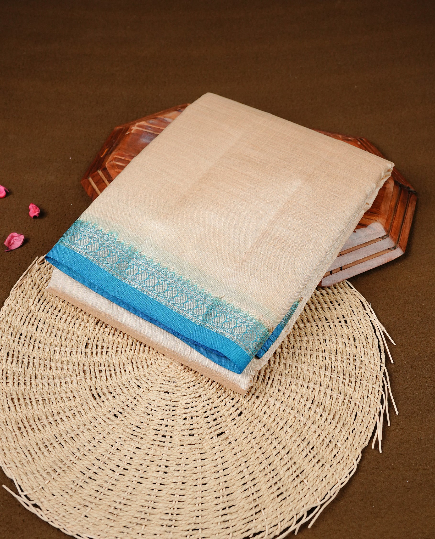 Cream colour Semi Tussar silk saree featuring an elegant plain body, accentuated by a contrast Blue border adorned with intricate gold Mango zari work, paired with a matching blouse piece.