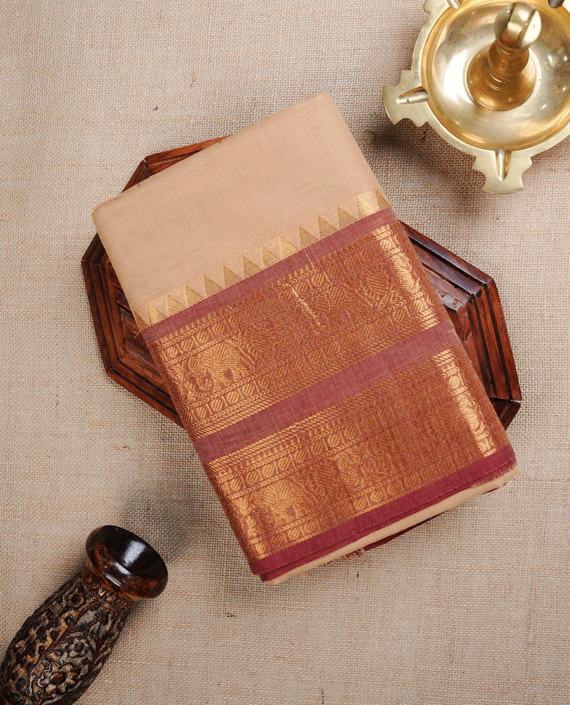 Cream colour chettinad cotton saree featuring Elegant plain body, complemented by contrast Brown colour with Gold zari border, paired with matching blouse piece.