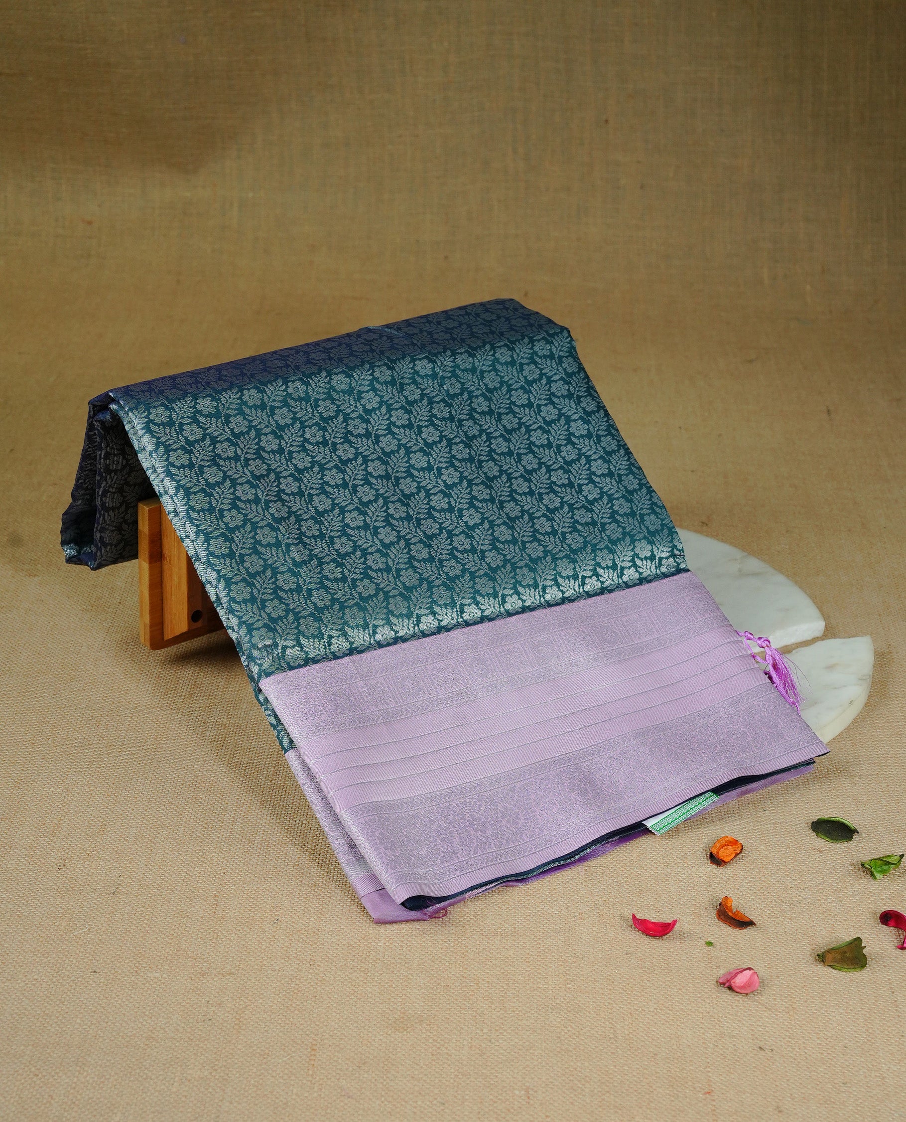 Green colour semi silk saree featuring Silver zari Floral pattern on body, complemented by contrast Purple colour with silver zari border, comes with matching blouse piece.