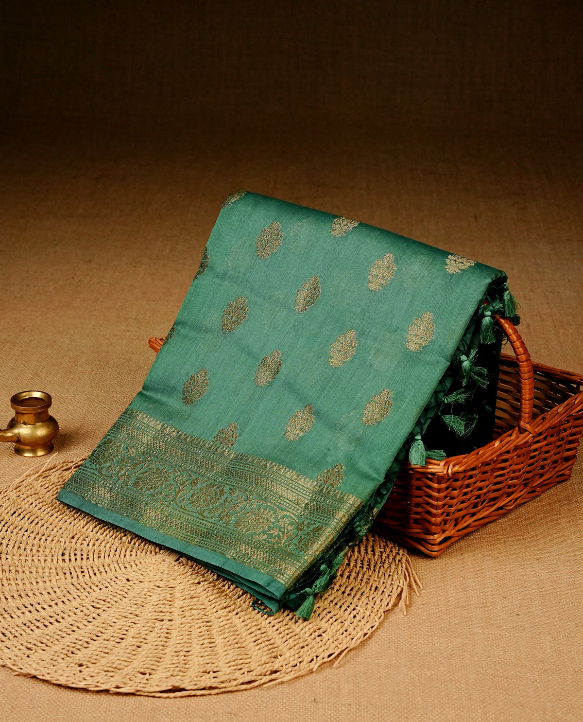 Sea green colour Banaras silk saree featuring gold zari buttas on body, complemented by self colour with zari border, comes with matching blouse piece.
