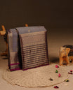 Grey colour Traditional Kancheepuram silk saree featuring gold zari motifs on body, enhanced with contrast Purple with traditional border, paired with matching blouse piece.