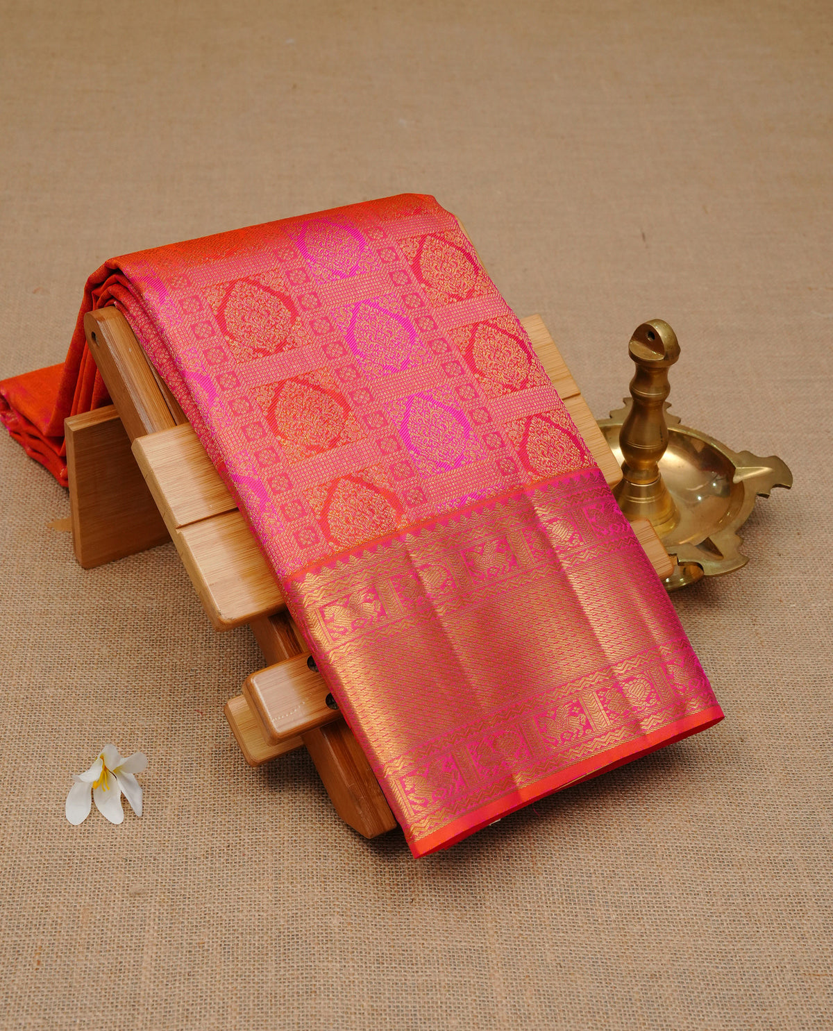 Orange colour pure wedding silk saree featuring gold zari Designed with magenta box pattern on body,complemented by self colour with traditional border, comes with matching blouse piece.
