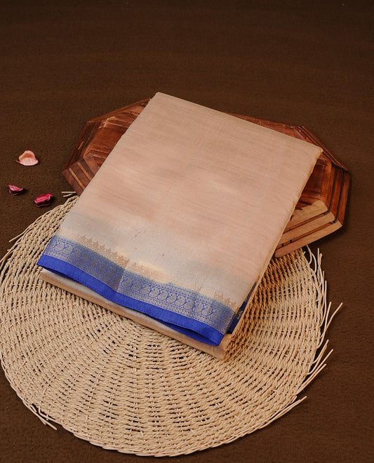 Cream colour Tussar silk saree Featuring Elegant Plain body, complemented by Contrast blue colour with gold zari border, paired with matching blouse piece.