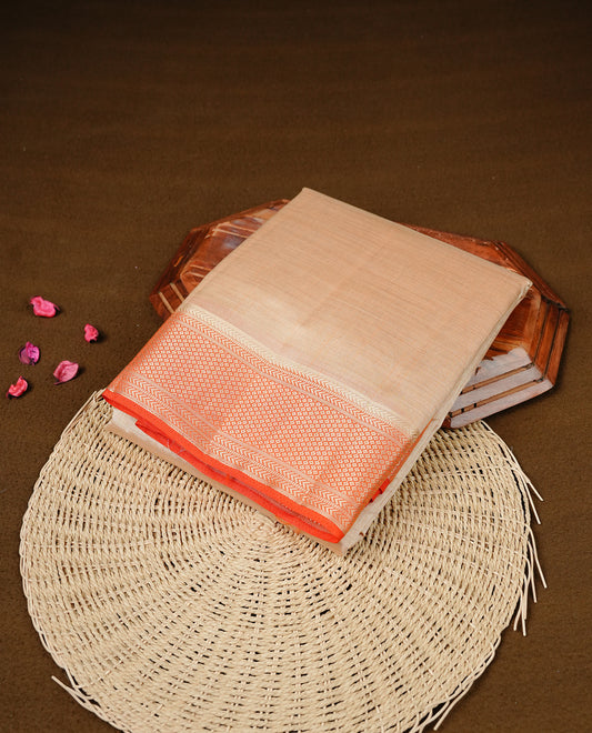 Cream colour Semi Tussar silk saree featuring an elegant plain body, accentuated by a contrast Orange border adorned with intricate gold zari work, paired with a matching blouse piece.