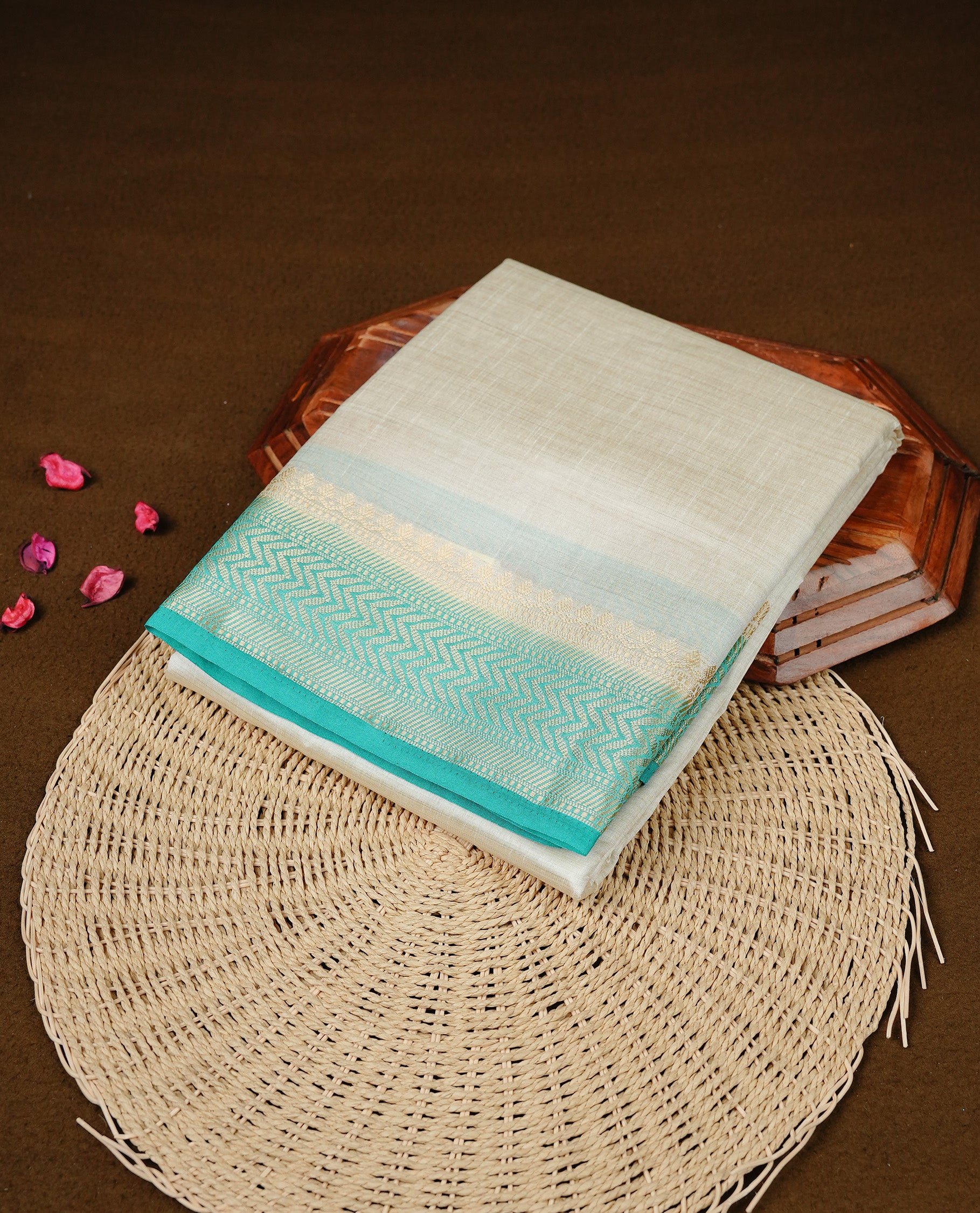 White cream colour Semi Tussar silk saree featuring an elegant plain body, accentuated by a contrast Aqua border adorned with intricate gold zigzag zari work, paired with a matching blouse piece.