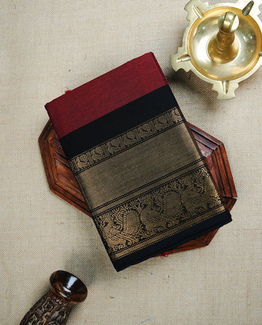 Maroon colour chettinad cotton saree featuring Elegant plain body , complemented by contrast Black colour with traditional Border, paired with matching blouse piece.