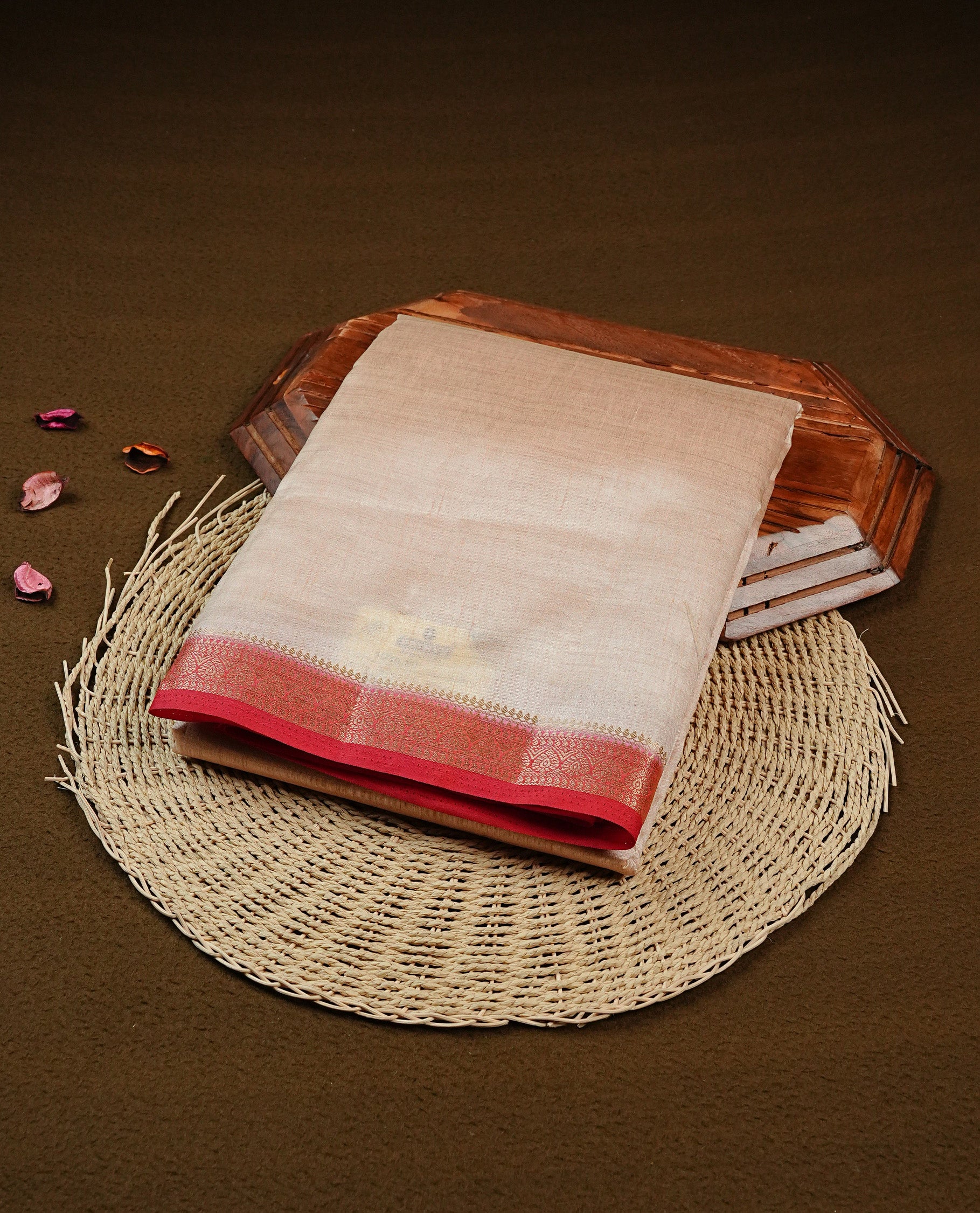 Cream colour Semi Tussar silk saree featuring an elegant plain body, accentuated by a contrast Red border adorned with intricate gold zari work, paired with a matching blouse piece.
