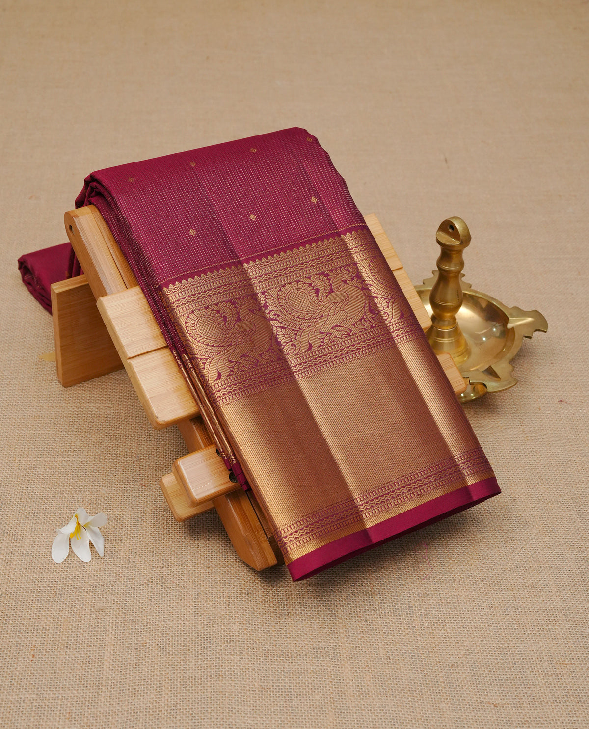 Maroon Colour Pure Wedding silk saree featuring Gold zari Dotted stripes with small buttas on body, complemented by self colour with traditional border, comes with matching blouse piece.