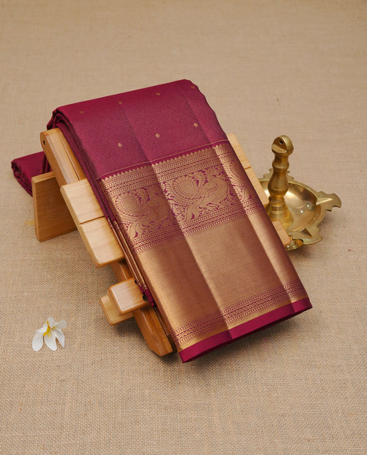 Maroon Colour Pure Wedding silk saree featuring Gold zari Dotted stripes with small buttas on body, complemented by self colour with traditional border, comes with matching blouse piece.