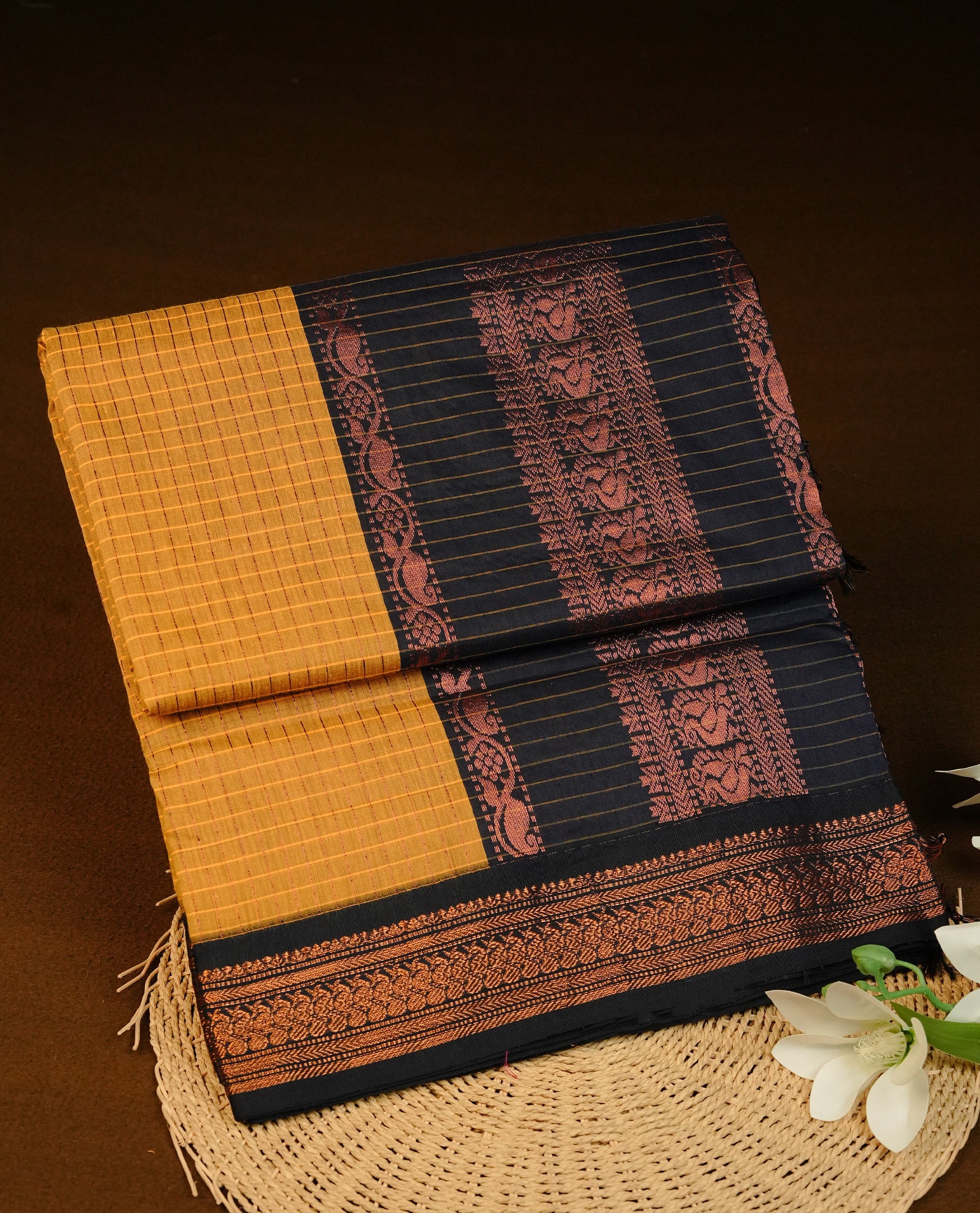 Yellow colour Kalyani cotton saree featuring Gold zari check pattern on body, complemented by Contrast Navy Blue colour with grand gold zari border & pallu, matching blouse piece