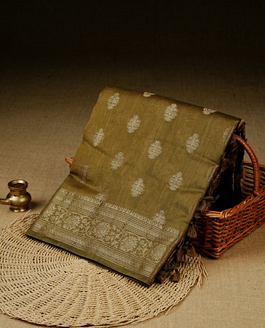 Olive colour Banaras silk saree featuring gold zari buttas on body, complemented by self colour with zari border, comes with matching blouse piece.