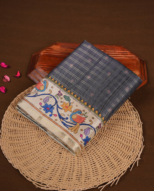 Gray colour semi tusser silk saree featuring gold zari check pattern with floral butti motifs, with contrast floral kodi & bird pattern and paired with matching blouse.