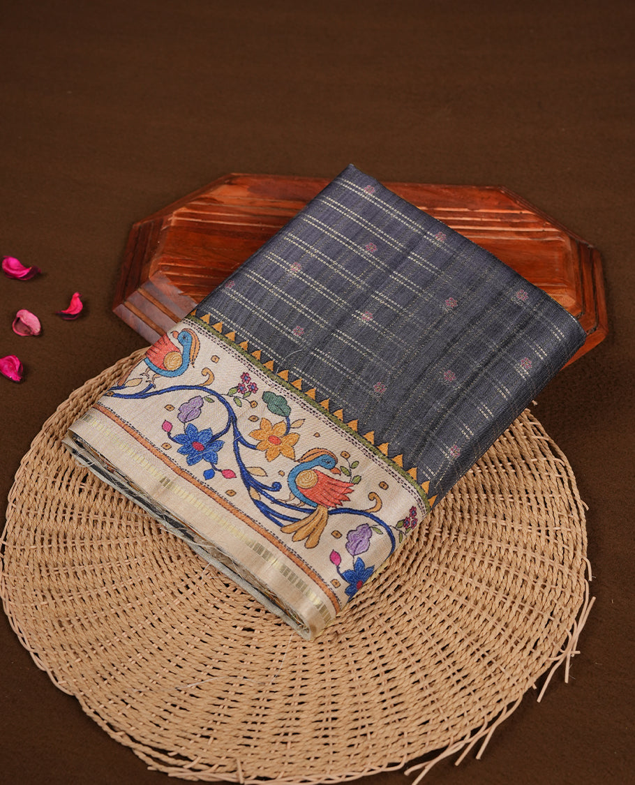 Gray colour semi tusser silk saree featuring gold zari check pattern with floral butti motifs, with contrast floral kodi & bird pattern and paired with matching blouse.