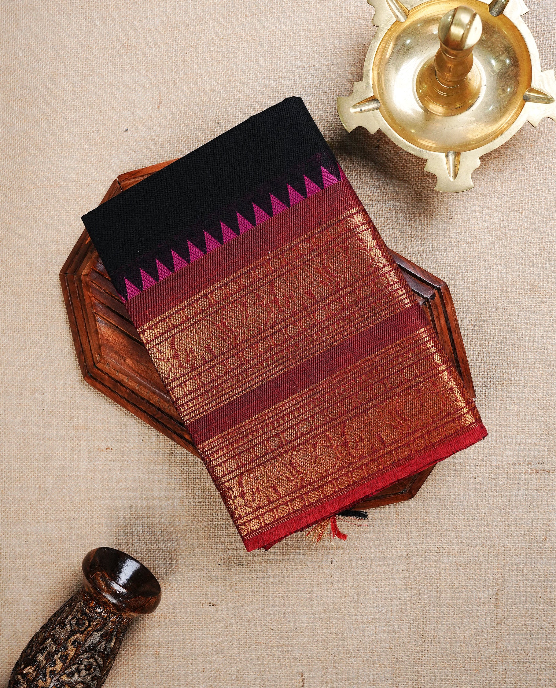 Black colour chettinad cotton saree featuring  Plain body, complemented by  Red Colour With Gold Zari border, paired with matching blouse piece.