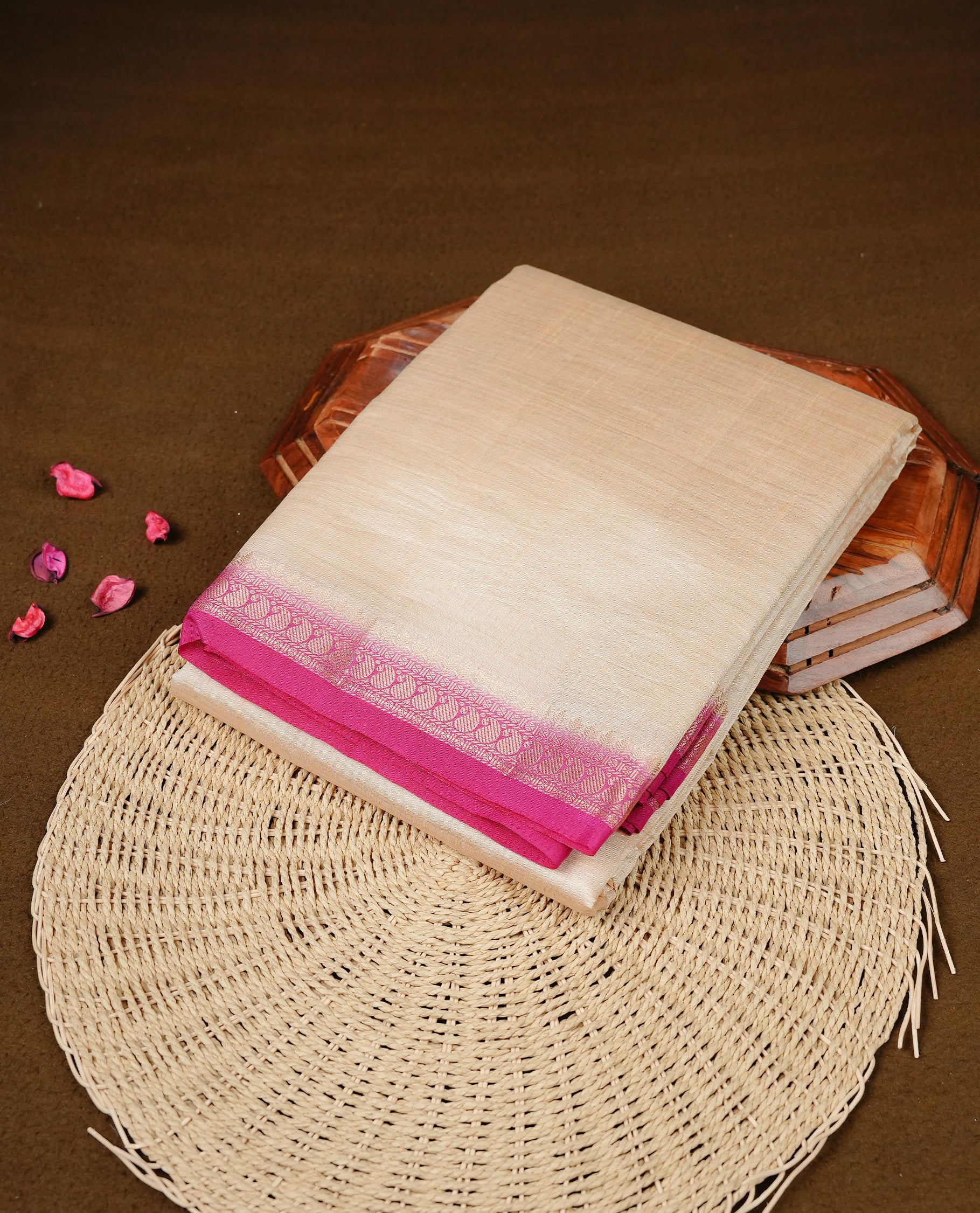 Cream colour Semi Tussar silk saree featuring an elegant plain body, accentuated by a contrast Pink border adorned with intricate gold Mango zari work, paired with a matching blouse piece.