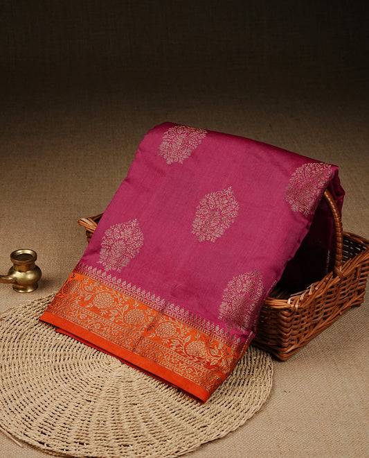 Magenta colour banaras saree featuring gold zari motifs on body, complemented by contrast orange colour with gold zari border, comes with matching blouse piece.