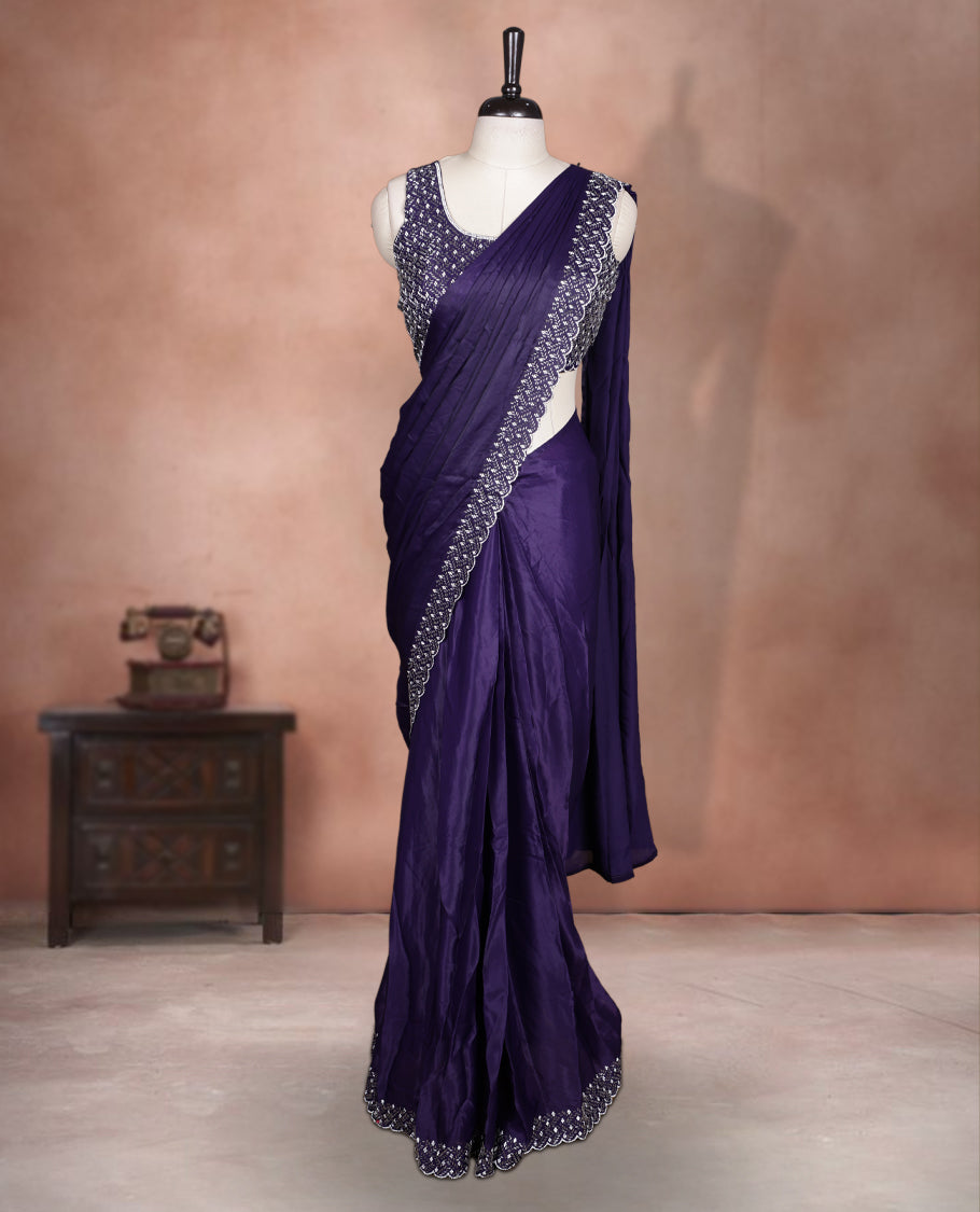 Elegant deep purple colour ready to wear saree adorned with rich white stone and bead embroidery along the border and pallu, paired with a heavily embellished matching blouse for a grand festive look.