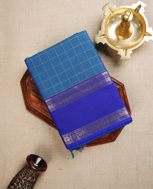 Peacock colour chettinad cotton saree featuring  Gold Zari Check Pattern  on body, complemented by Contrast Ink Blue Colour With Gold Zari border, paired with matching blouse piece.